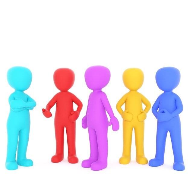 people with different colors standing and talking together