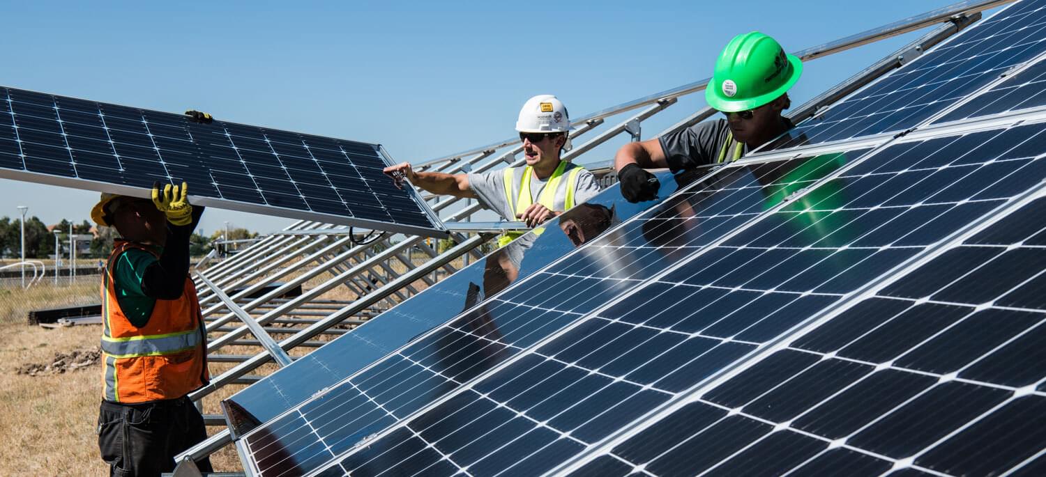 three man installing solar panels